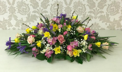 Colourful Casket Spray - A 3FT casket spray featuring a mix of spring flowers in pink, purple, and yellow tones, offering a vibrant tribute.